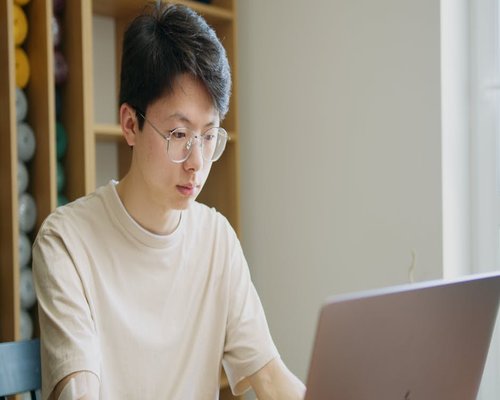 A person working comfortably on a laptop in a well-lit home office